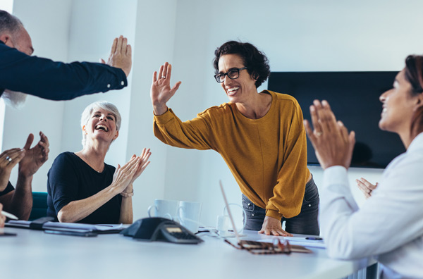 Motiverade medarbetare som gör en high-five på kontoret