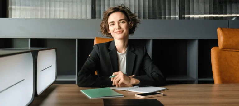 HR-ansvarig sitter vid skrivbord och arbetar med dokument kring lönepolicy på kontor.